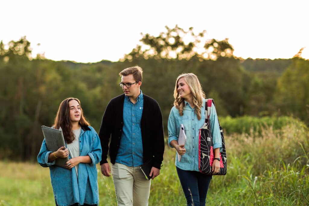 Toccoa Falls College students walk in a pasture