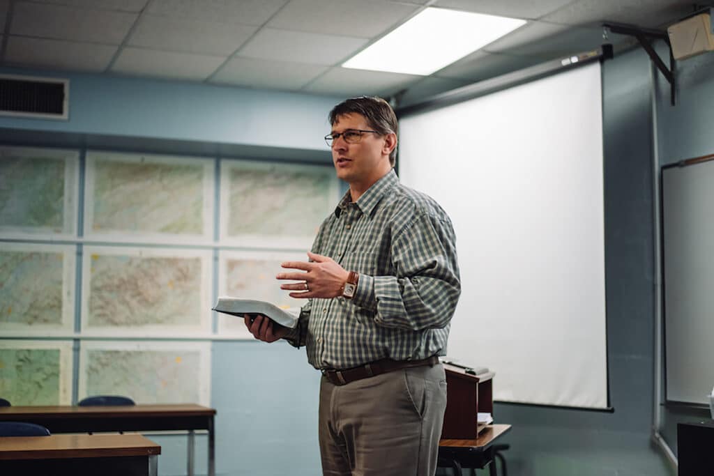 A professor addresses his classroom from the front