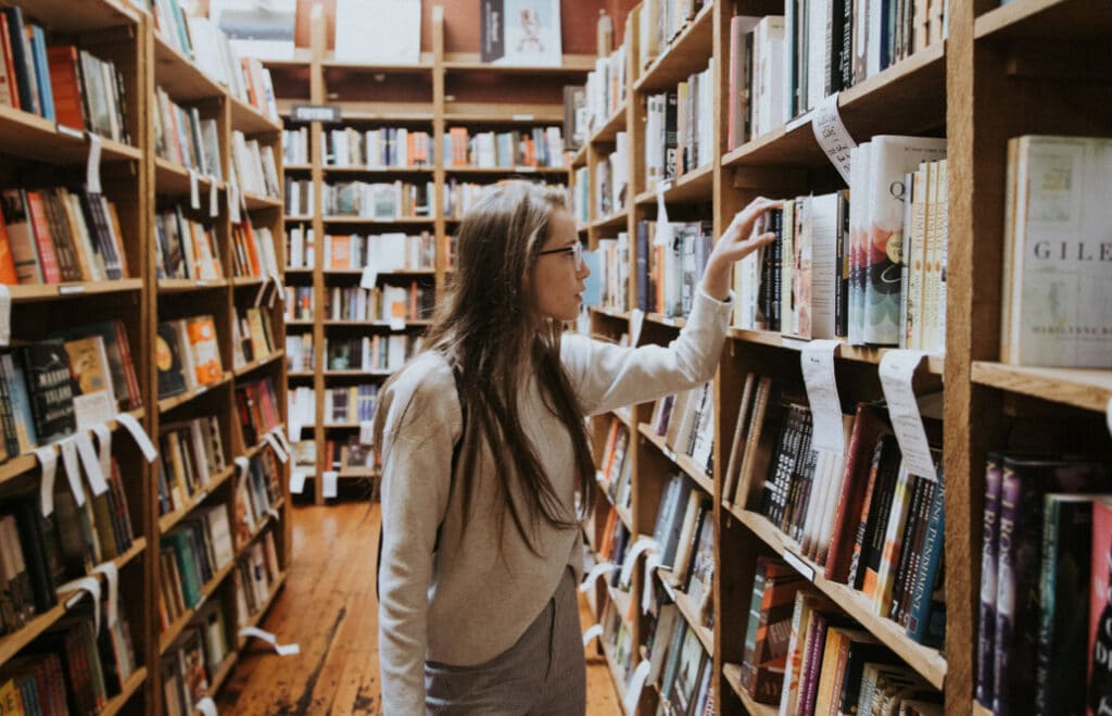 Woman with glasses walking through library