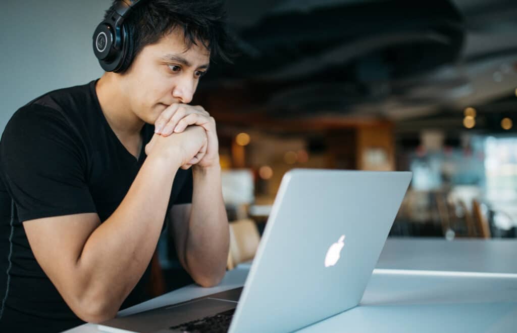 Young man wearing headphones working on a laptop