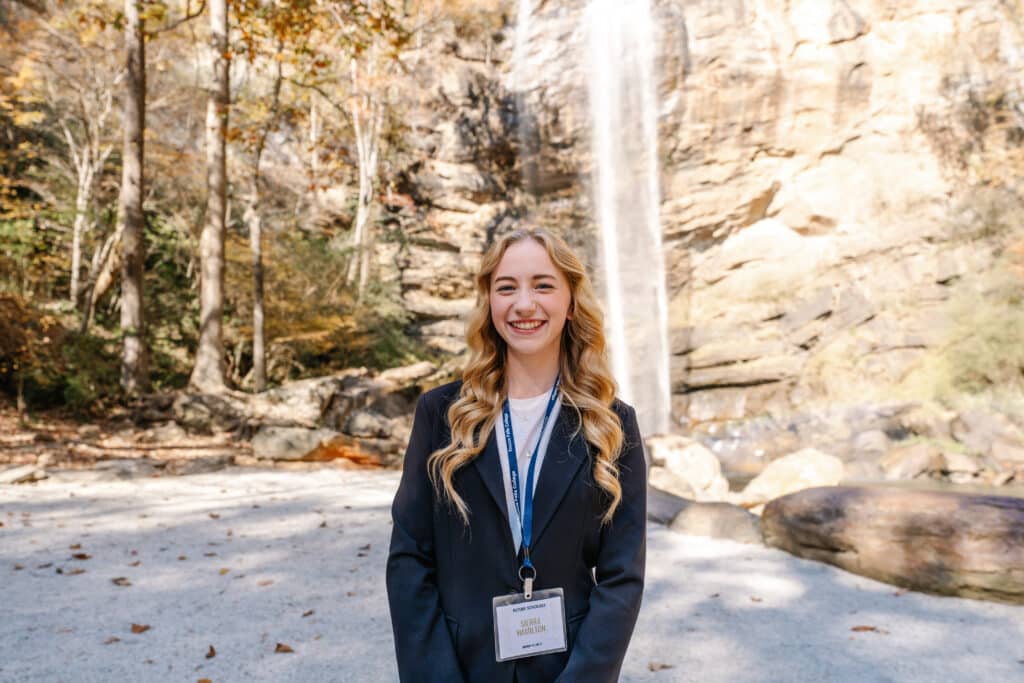 Girl standing in front of waterfall